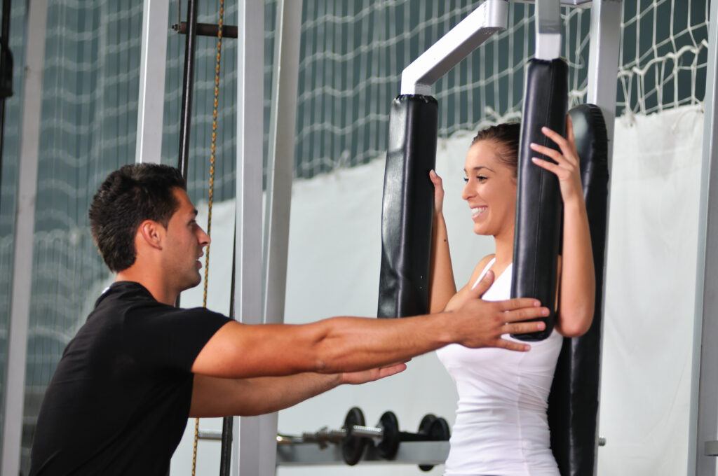 woman in the fitness gim working out with personal trainer coach